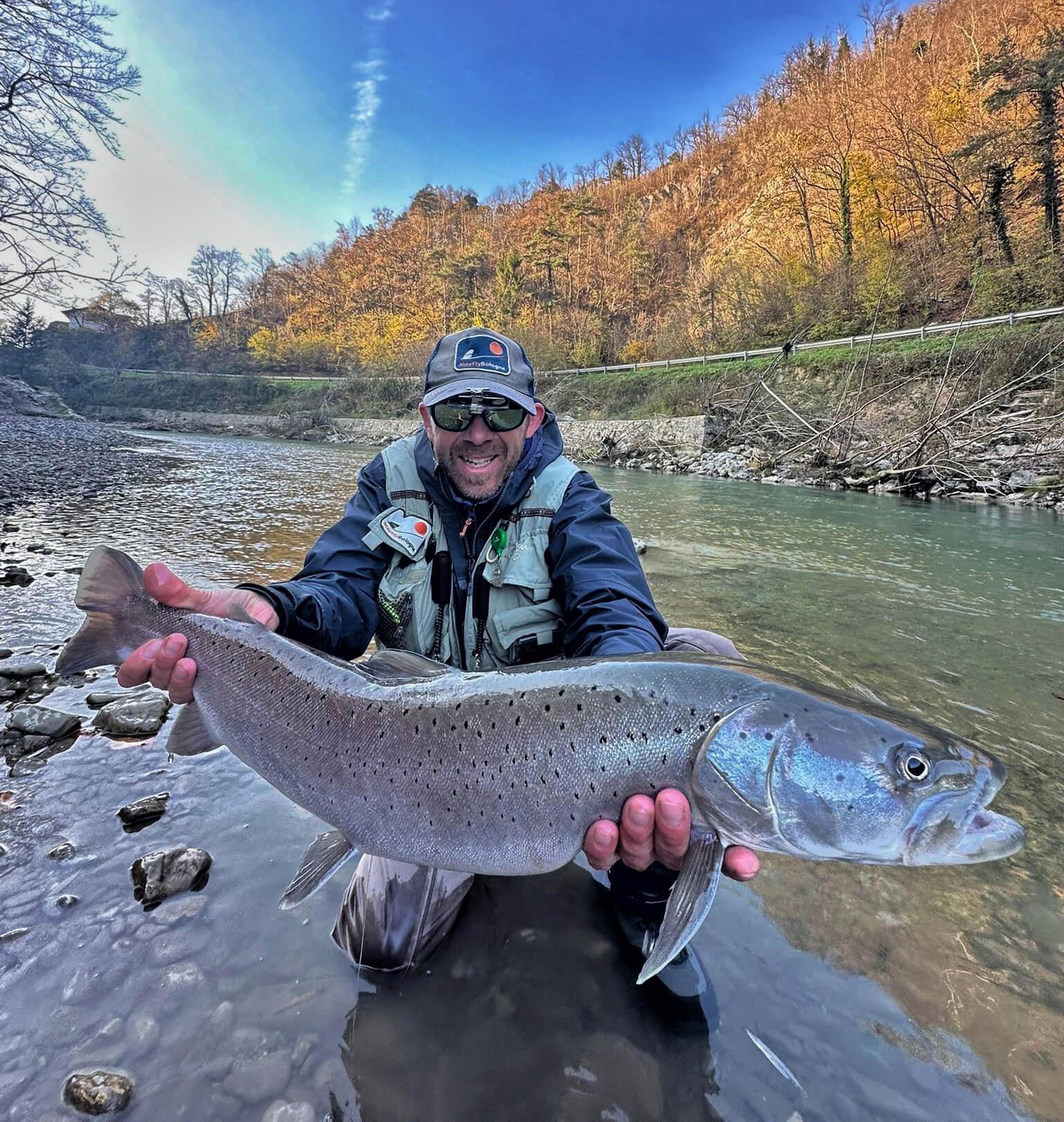 Fly angler in action showing off a cool hucho catch. Fly fishing in the Savinja valley, Mozirje, Slovenia-