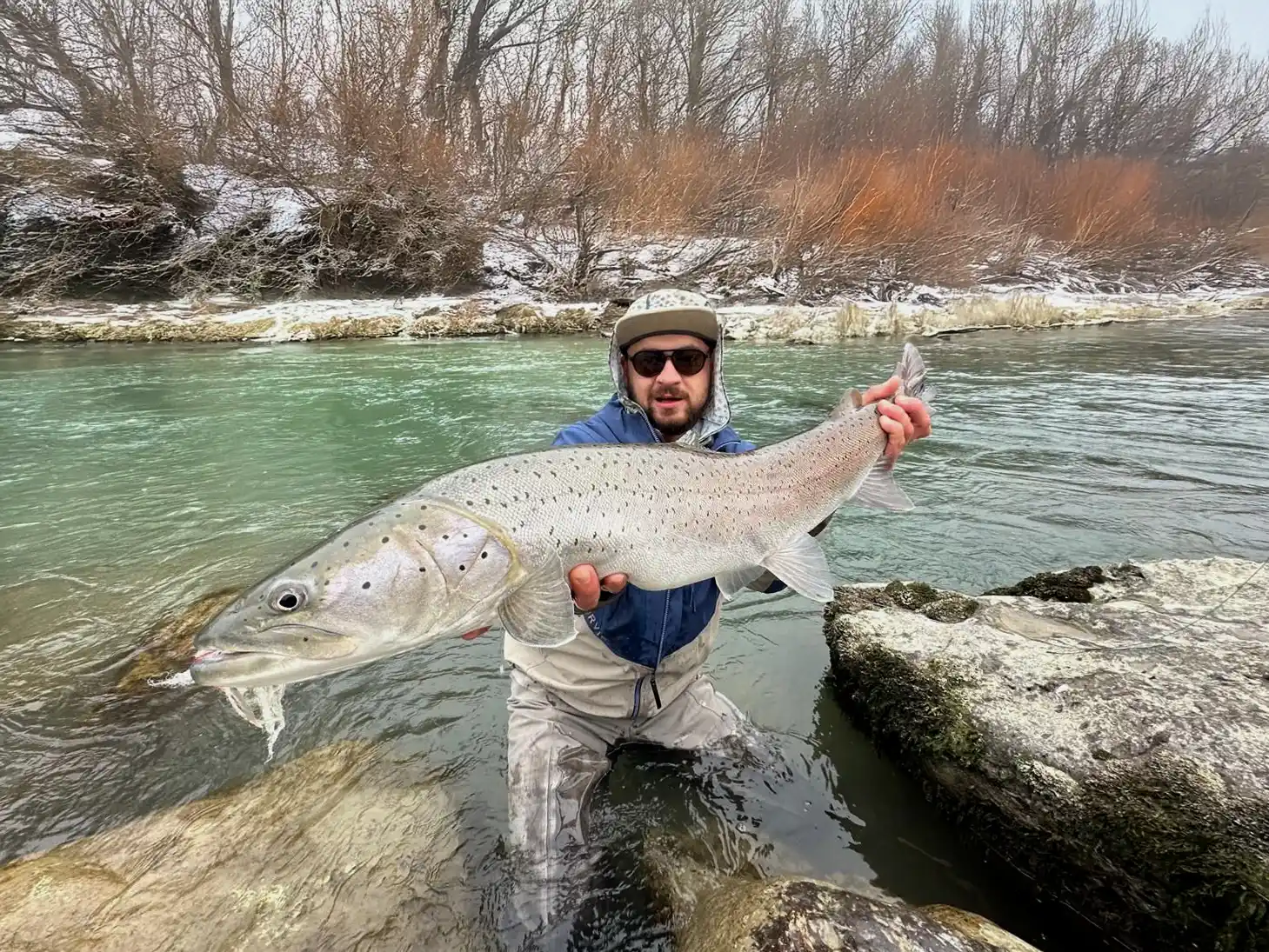 Fly angler in action with a large hucho, caught with a streamer made by Tommy Fly UV materials and a Partridge hook.