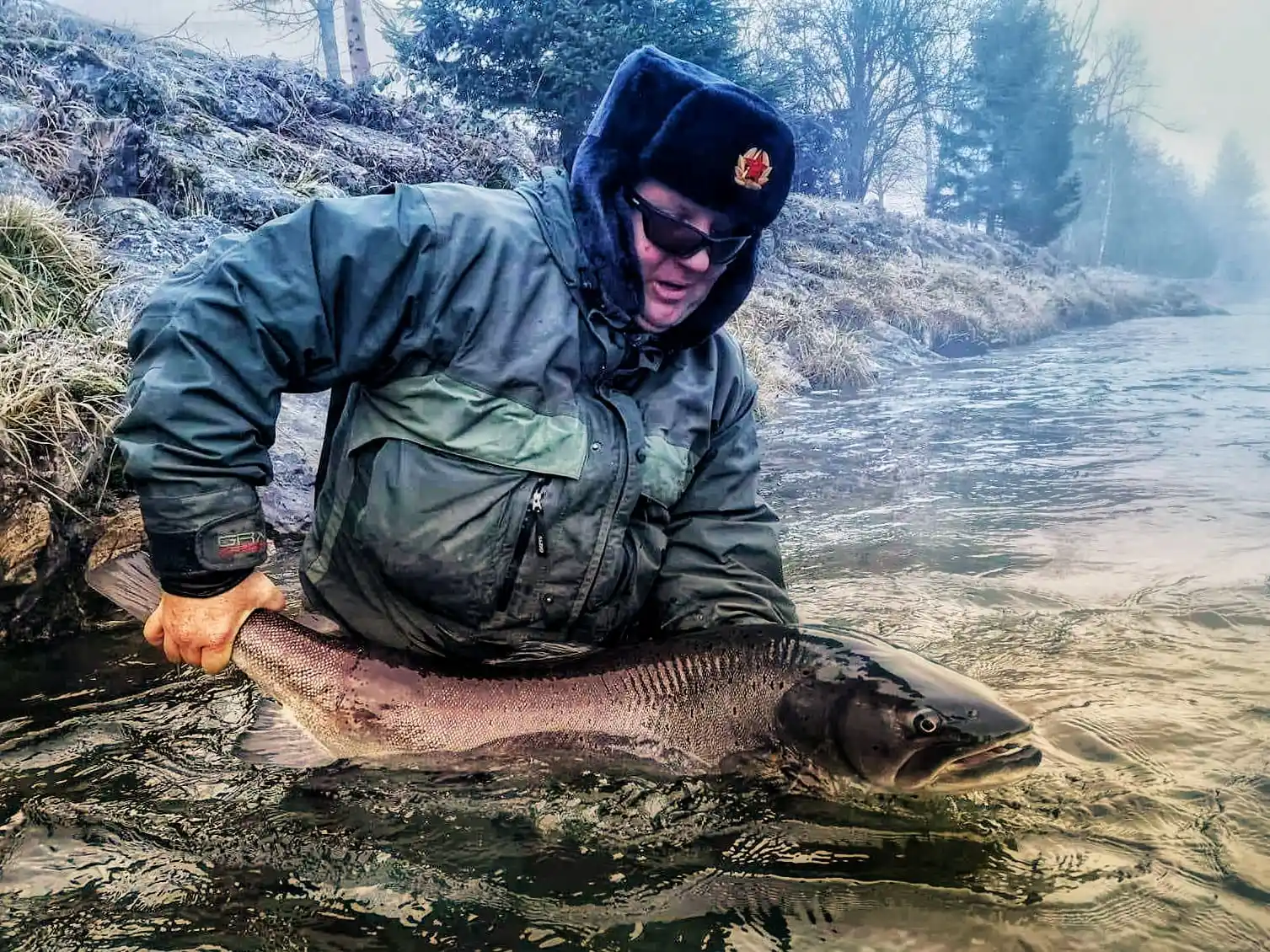 Fly angler in action with a large hucho, caught with a streamer made by Tommy Fly UV materials and a Partridge hook. Kamniska Bistrica domzale.