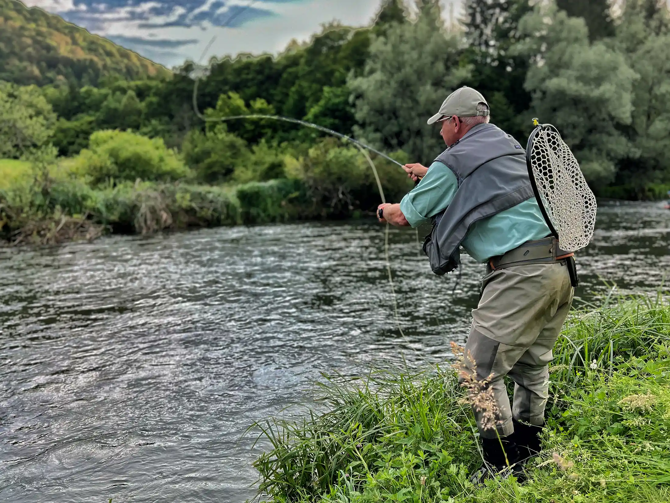Fly angler in action on Krka River, Slovenia. Great place for dry fly fishing for large brown trout!