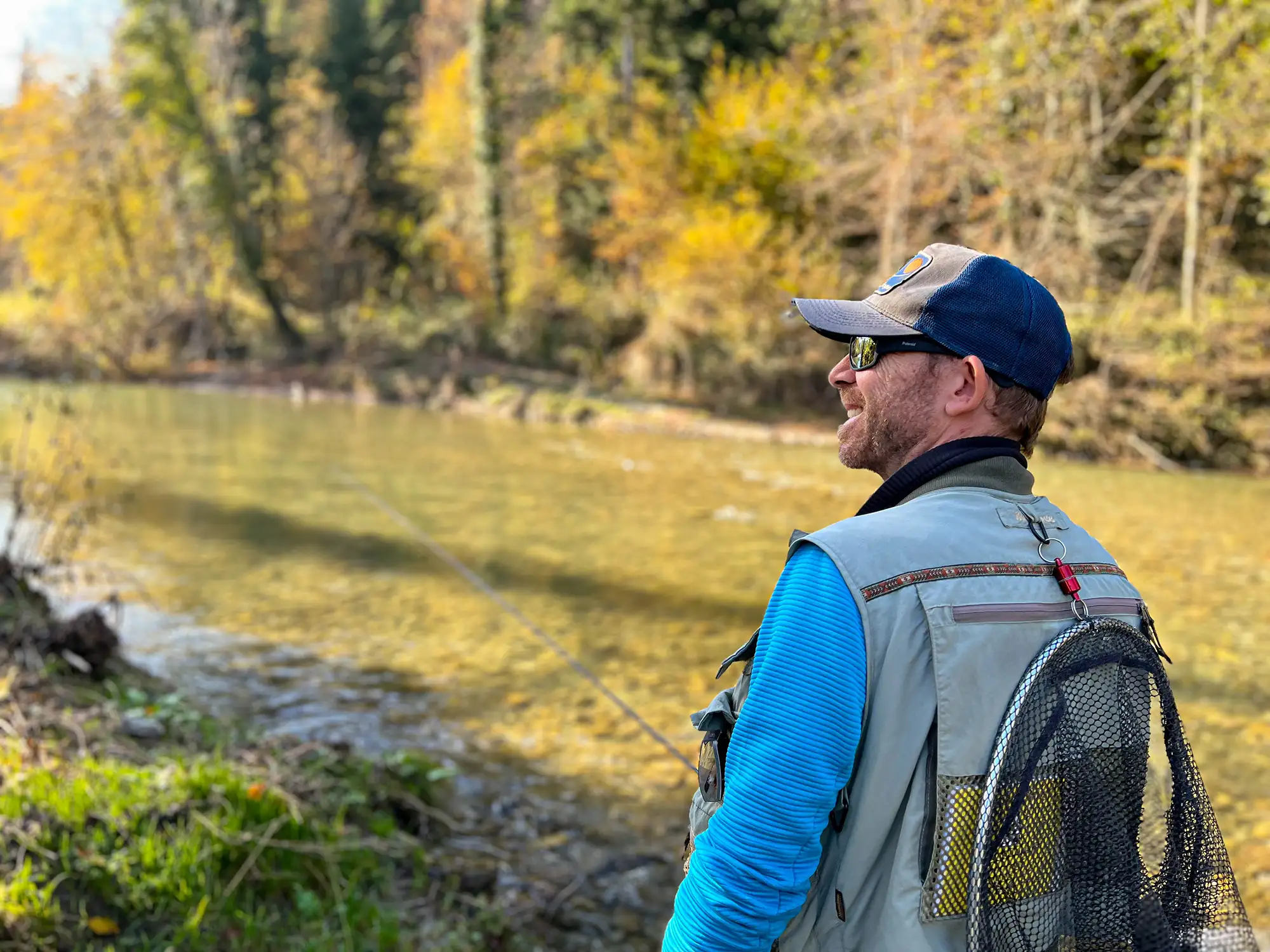A fly angler in search of grayling on a sunny autumn day along the Dreta River.